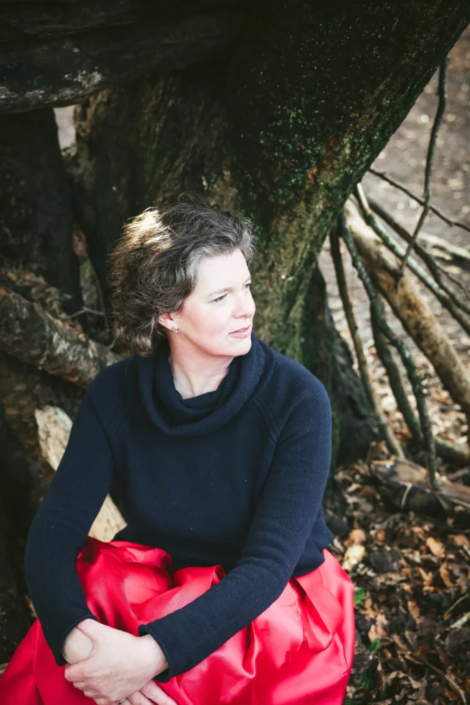 woman in red skirt sitting by tree